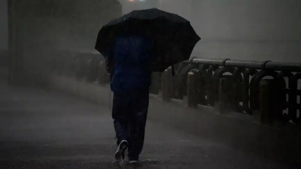 pessoa no frio segurando uma sombrinha