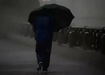 pessoa no frio segurando uma sombrinha