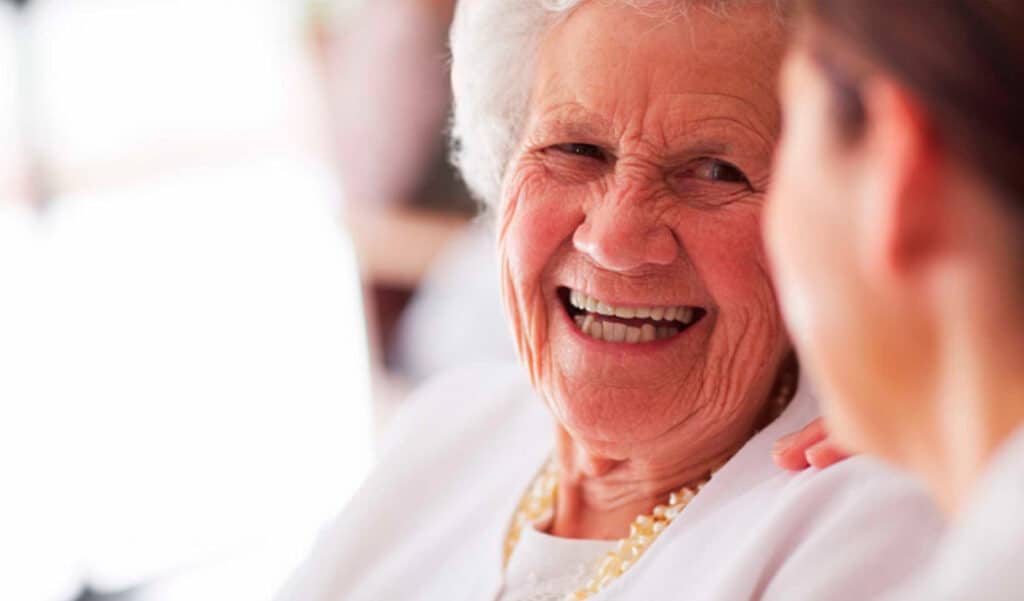 Aposentada feliz e sorrindo com o pagamento do 13º salário do INSS. (Fonte: shutterstock).