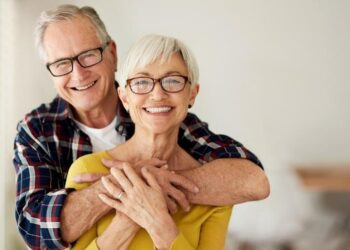 Casal abraçado e feliz com os benefícios para idosos. (Fonte: iStock).