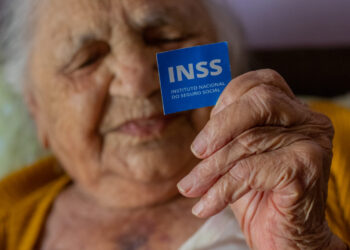 mulher segurando cartão que dá direito a aposentadoria do inss