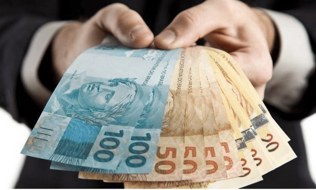 pessoa segurando cédulas de dinheiro