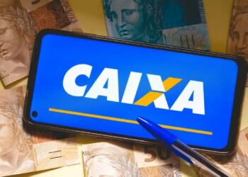 celular aberto no caixa tem ao lado de notas de 50 reais