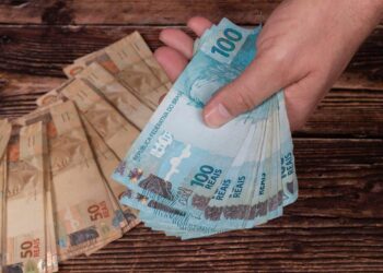 Pagamento do abono salarial em notas de 50 e 100 reais. (Fonte: Alexandre Zorek / Shutterstock).