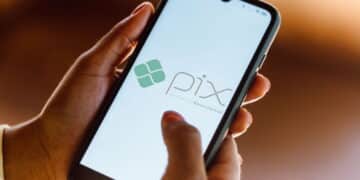 Mão segurando celular aberto na tela do pix. (Fonte: shutterstock).
