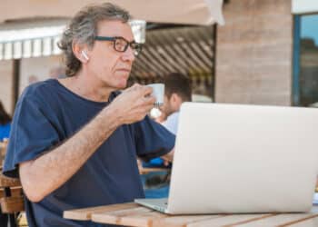homem tomando café usando laptop (Fonte: Freepik)