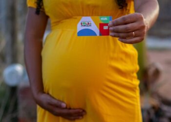 mulher grávida segurando cartão do bolsa família