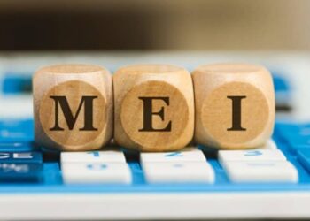 três cubos de madeira com as letras 'm', 'e' e 'i' formando a palavra 'mei', sobre uma calculadora