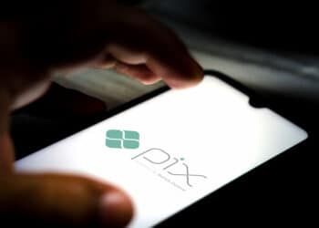 close up de mão sobre smartphone com logo do pix na tela