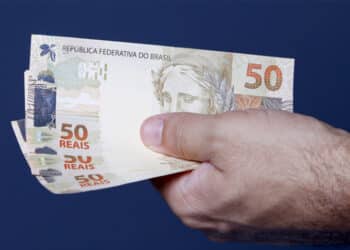 close up de mão segurando 3 notas de 50 (Fonte: Onze)