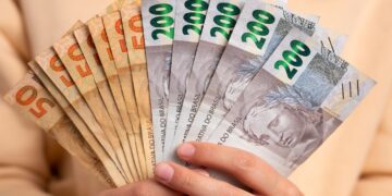 maos segurando dinheiro notas de 200 e 50