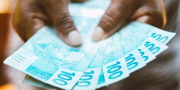 mulher com notas de cem reais