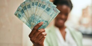 Young african american businesswoman smiling happy holding brazilian real banknotes at the city