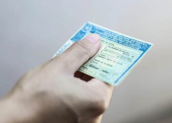 mão segurando uma carteira de habilitação