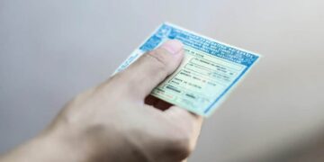 mão segurando uma carteira de habilitação