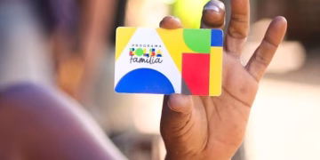 mão segurando um cartão de pagamento do bolsa família