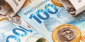 notas de cem reais e moedas de 1 real