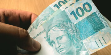 homem com notas de cem reais