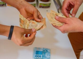 homem e mulher com notas de reais