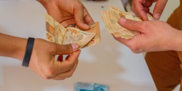 homem e mulher com notas de reais