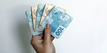 mulher com notas de cem e cinquenta reais