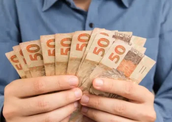 pessoa segurando notas de dinheiro de cinquenta reais