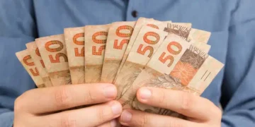 pessoa segurando notas de dinheiro de cinquenta reais