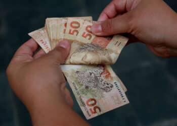 mulher com notas de cinquenta reais
