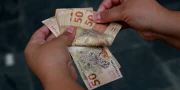 mulher com notas de cinquenta reais