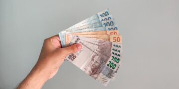 homem segurando notas de reais